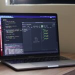 a laptop computer sitting on top of a wooden desk
